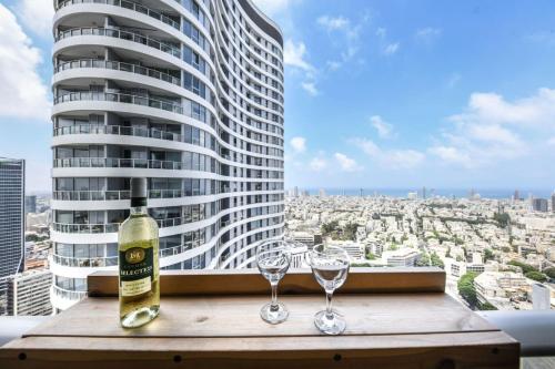 Una botella de vino sobre una mesa con dos copas. en Spacious 3BR Duplex w Balcony in City Center with Mamad by Sea N' Rent, en Tel Aviv