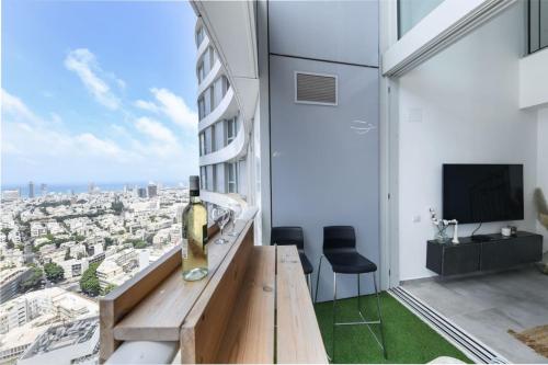 Una habitación con una botella de vino en una mesa en un edificio. en Spacious 3BR Duplex w Balcony in City Center with Mamad by Sea N' Rent, en Tel Aviv