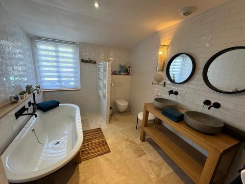 une salle de bain avec deux lavabos et une baignoire dans l'établissement Escapades Océanes Ile de Ré La Rochelle, à Sainte-Marie de Ré