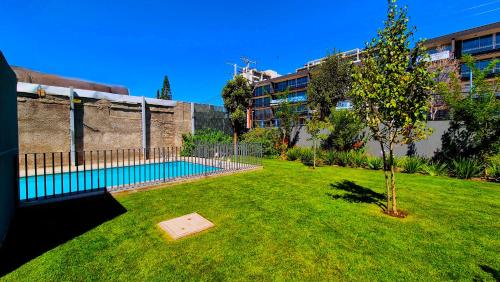 a small tree in a yard with a swimming pool at Moderno y Comodo Departamento en Ñuñoa 2D1B Piso 6 in Santiago