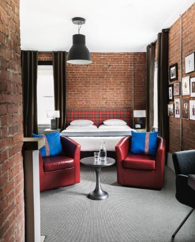 a bedroom with a bed and two chairs and a table at The George Montclair in Montclair