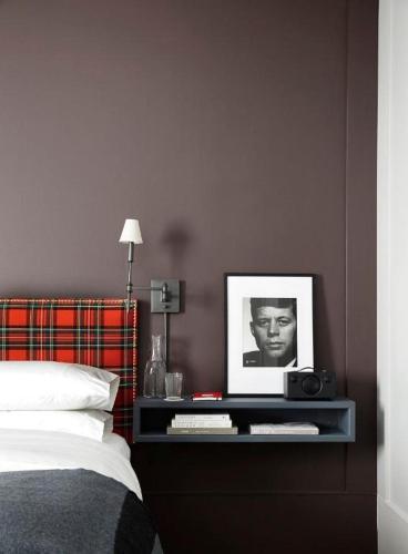 a bedroom with a bed and a table with a picture at The George Montclair in Montclair