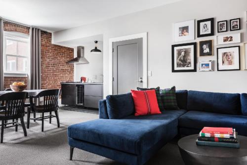 a living room with a blue couch and a table at The George Montclair in Montclair