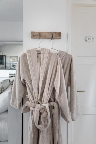 a robe hanging on a door in a room at The Gem of Neve Tzedek Stylish Home in Tel Aviv