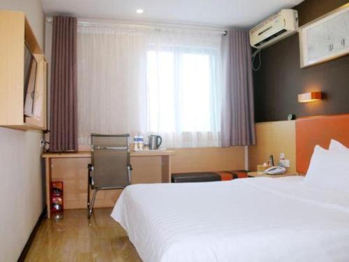 a hotel room with a bed and a desk and a window at 7 Days Premium·Xiamen Airport Xianglu in Xiamen