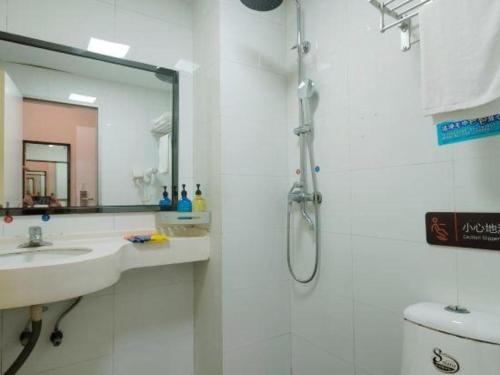 a bathroom with a shower and a sink and a mirror at 7 Days Premium·Xiamen Airport Xianglu in Xiamen
