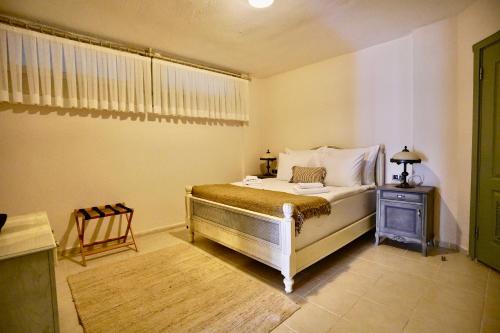a bedroom with a bed and a table with a chair at Cumbalıca Flora in Cesme