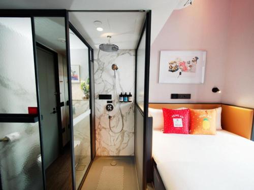 a bedroom with a shower and a bed in a room at Hotel Soloha @ Chinatown in Singapore