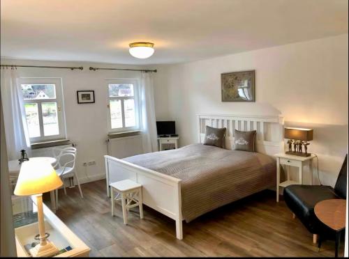 a bedroom with a bed and a desk and a couch at Charmante Ferienwohnung 1 im Schmöllerhäuschen in Stadt Wehlen