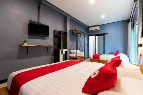 a bedroom with a large bed with red pillows at OYO 75305 T Park Pak Chong in Mu Si