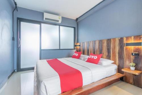 a bedroom with a large bed with red pillows at OYO 75305 T Park Pak Chong in Mu Si