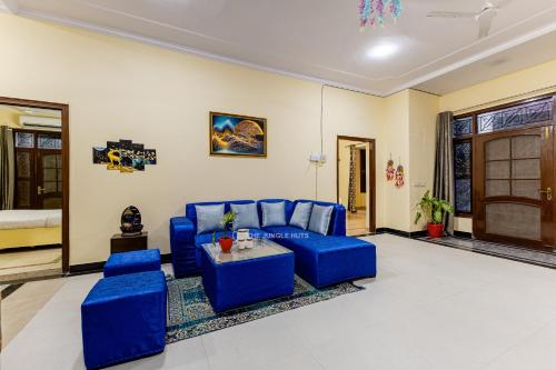 a living room with blue chairs and a couch at The Jungle Huts 6BHK With PVT Pool in Gurgaon