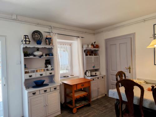 a kitchen with white cabinets and a wooden table at Ferienhaus Somloi Sellö in Somlószőlős