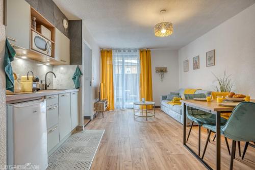 une cuisine et un salon avec une table et un canapé dans l'établissement COSY CAUSSADE Parking gratuit Jardinet Refait à neuf, à Caussade