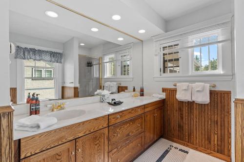 Un baño con lavabo y un espejo grande. en Harriet House, en Minneapolis