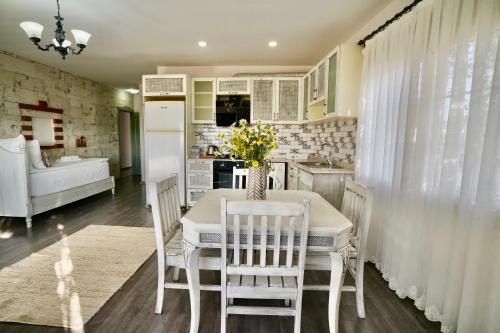 a kitchen with a table and chairs and a white refrigerator at Cumbalıca Flora in Cesme