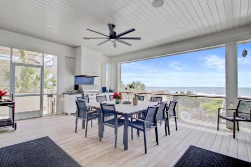 a dining room with a table and chairs and a large window at 710 Ocean Boulevard AvantStay Oceanfront Private Pool Rooftop Deck in Mount Pleasant