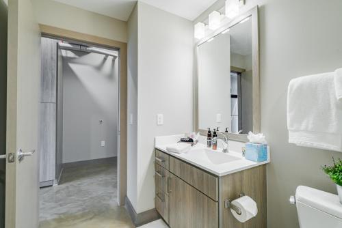 a white bathroom with a sink and a mirror at Sable 704 - One Bedroom in Minneapolis