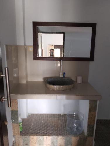 a bathroom with a sink and a mirror at Kadek Homestay in Amed