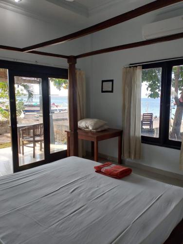 a bedroom with a bed with a view of the ocean at Kadek Homestay in Amed