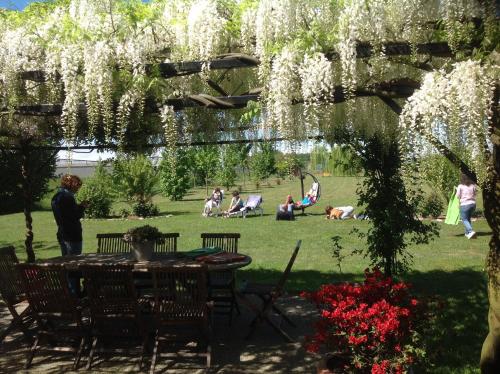 a garden with a table and people in the grass at B&B La Castellana in Borgo Lavezzaro