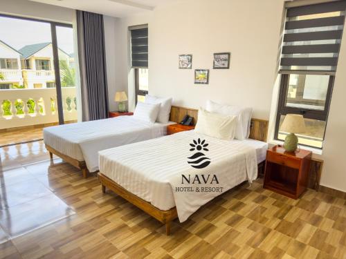 two beds in a hotel room with a window at Nava Hotel & Resort in Dong Hoi