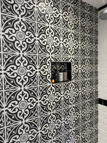 a bathroom with a black and white tile wall at Springbank Manor in Darwen