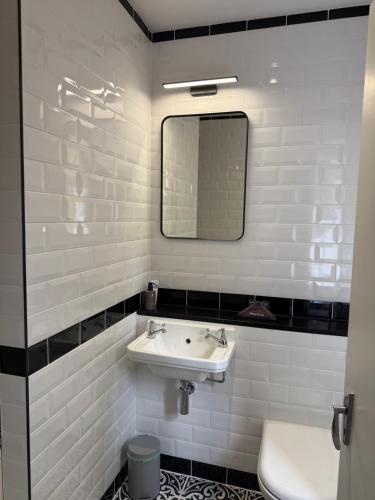a white bathroom with a sink and a mirror at Springbank Manor in Darwen