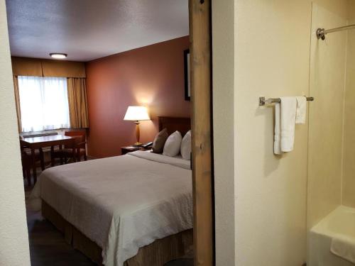 a hotel room with a bed and a bathroom at Airport Inn in Boise