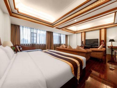 a bedroom with a large bed and a living room at Kunming Tailong Hongrui Hotel in Kunming