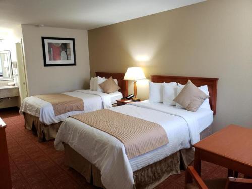 a hotel room with two beds and a table at Airport Inn in Boise