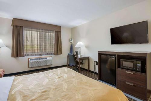 a hotel room with a bed and a flat screen tv at Quality Inn in Edgerton
