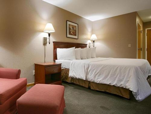 a hotel room with a large bed and two chairs at Best Western Galt Inn in Galt