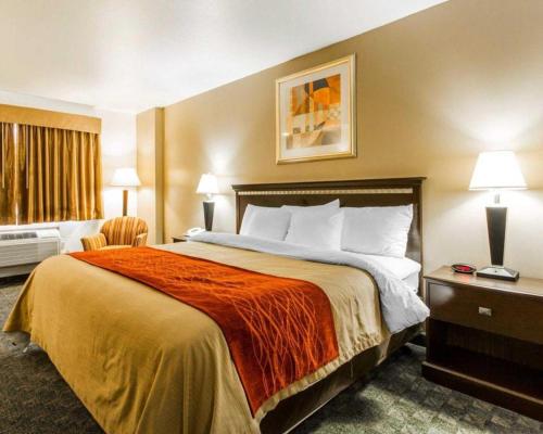 a hotel room with a large bed with orange blanket at Quality Inn in Edgerton