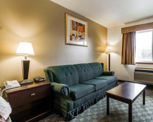 a living room with a green couch in a hotel room at Quality Inn in Edgerton