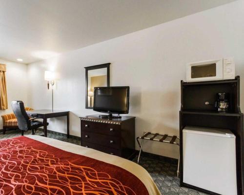 a hotel room with a bed and a desk and a television at Quality Inn in Edgerton