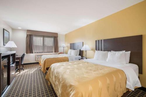 a hotel room with two beds and a desk at Quality Inn in Edgerton