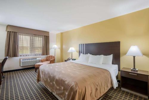 a hotel room with a large bed and a chair at Quality Inn in Edgerton