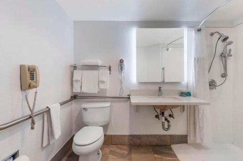 a bathroom with a toilet and a sink and a phone at Best Western Galt Inn in Galt