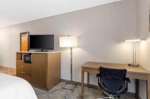 a room with a desk with a bed and a television at Best Western Galt Inn in Galt