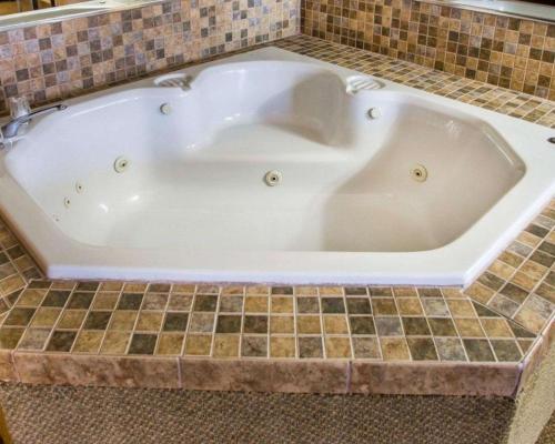 a large white bath tub sitting in a bathroom at Quality Inn & Suites Kimberly - Appleton East in Kimberly