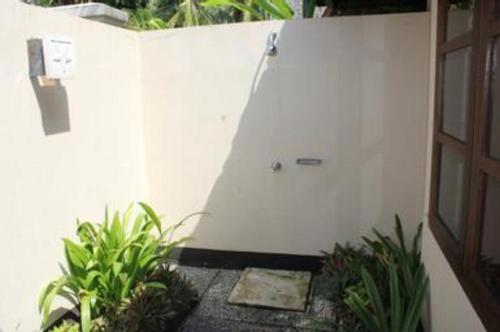a white wall with a door and some plants at Tanjung Lesung Beach Hotel in Carita