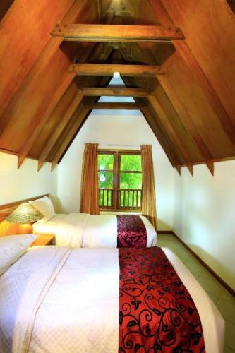 a bedroom with two beds and a window at Tanjung Lesung Beach Hotel in Carita