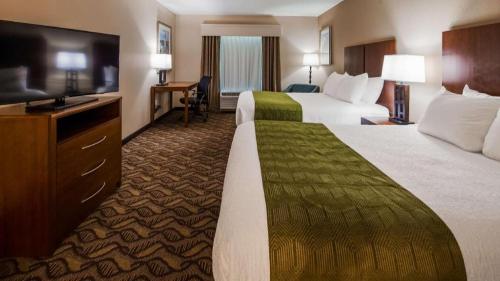 a hotel room with two beds and a flat screen tv at Best Western Athens in Athens