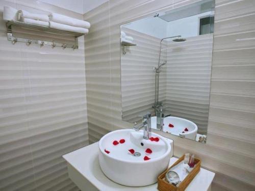 a bathroom with a white sink and a mirror at Barcelona Hotel Nha Trang in Nha Trang