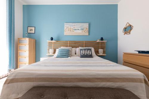a bedroom with a large bed with blue walls at Marzamemi Terrazza vista mare in Marzamemi