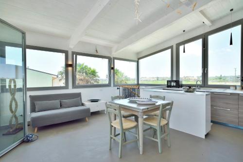 a kitchen and living room with a table and chairs at Marzamemi Terrazza vista mare in Marzamemi