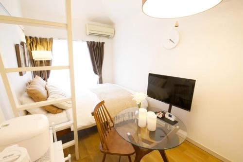 a small room with a glass table and a bed at スカイピア高砂 201 in Tokyo