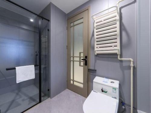 une salle de bain avec toilettes et douche en verre dans l'établissement Li Hao Hotel Beijing Capital Airport and Exhibition Center, à Pékin