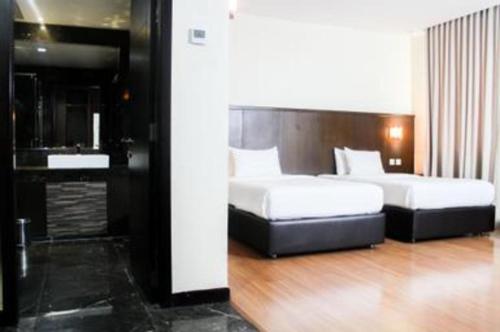 a hotel room with two beds and a sink at The BCC Hotel & Residence in Nagoya